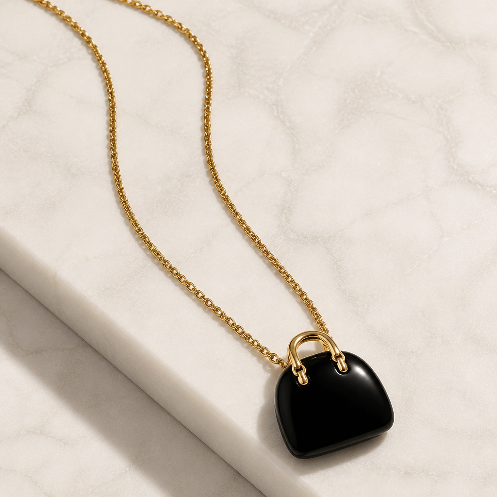 BLACK ONYX HANDBAG PENDANT ON GOLD COLORED STAINLESS STEEL CHAIN