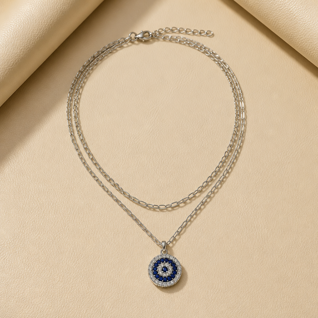 DOUBLE-LAYERED SILVER-TONE CHAIN NECKLACE WITH ROUND EVIL EYE PENDANT ACCENTED WITH BLUE AND WHITE CRYSTALS