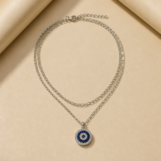 DOUBLE-LAYERED SILVER-TONE CHAIN NECKLACE WITH ROUND EVIL EYE PENDANT ACCENTED WITH BLUE AND WHITE CRYSTALS